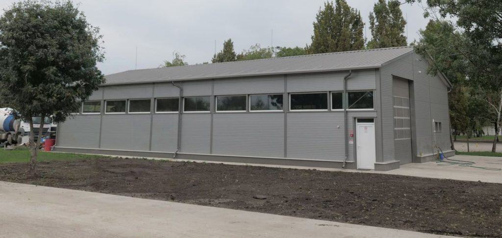 Montovaná hala zo sendvičových panelov s oknami, sekčnou bránou a sedlovou strechou